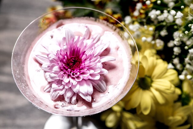 Close up of cocktail with flower on top in martini glass