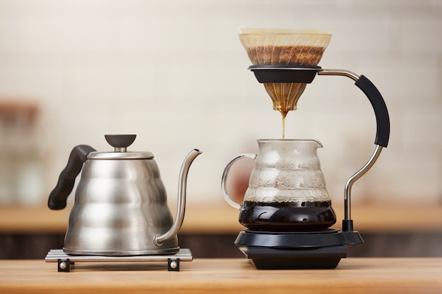 Close up of coffee brewing gadgets on wooden bar counter.