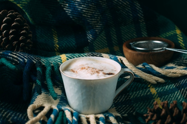 Foto gratuita tazza di caffè del primo piano con una coperta