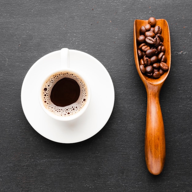 Tazza di caffè del primo piano con la paletta dei fagioli