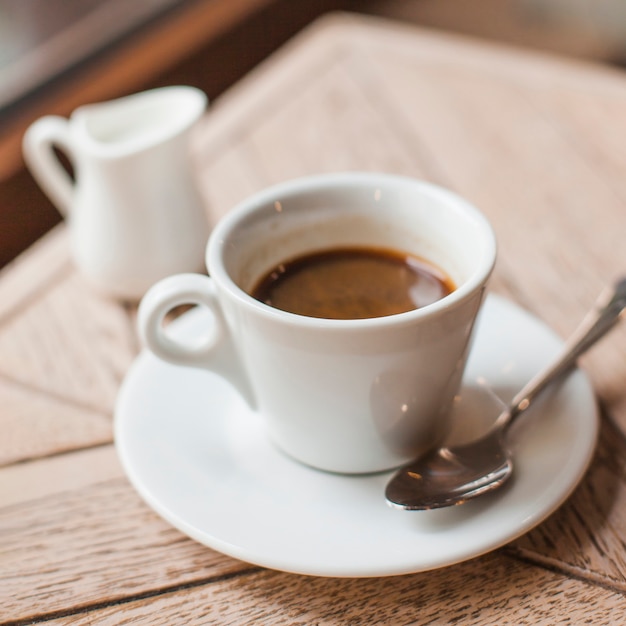 Free photo close-up of coffee cup on wooden table in caf�