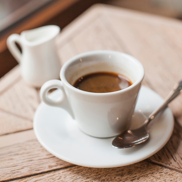 カフェの木製のテーブルの上のコーヒーカップのクローズアップ