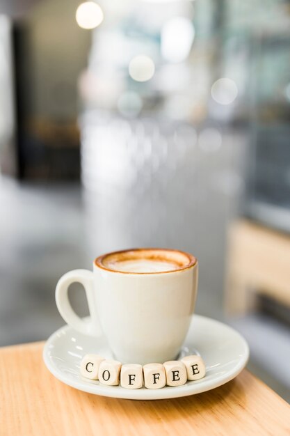 Close-up of coffee dice with coffee cup on wooden table