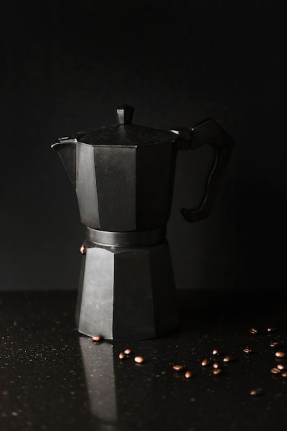 Free photo close-up of coffee maker with roasted coffee beans on black background