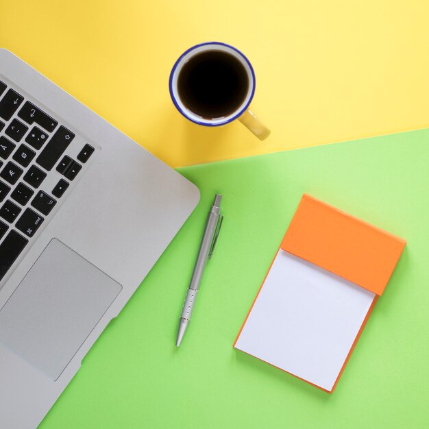 Close-up coffee and notepad near keyboard