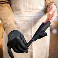 Free photo close-up coffee shop worker taking gloves off