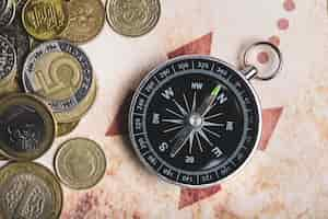 Free photo close-up of coins next to a compass