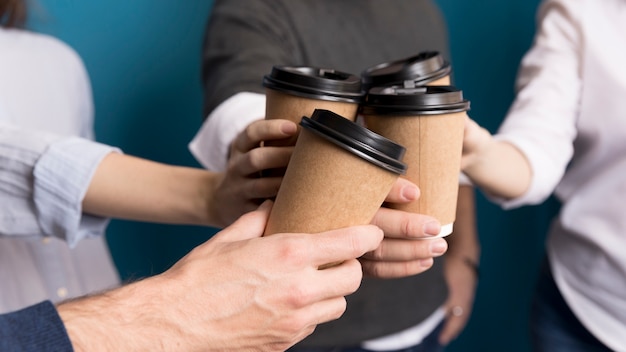 一緒にコーヒーを持っているクローズアップの同僚