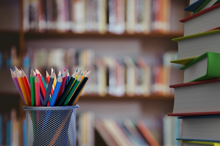 Free Photo close-up of colored pencils with books