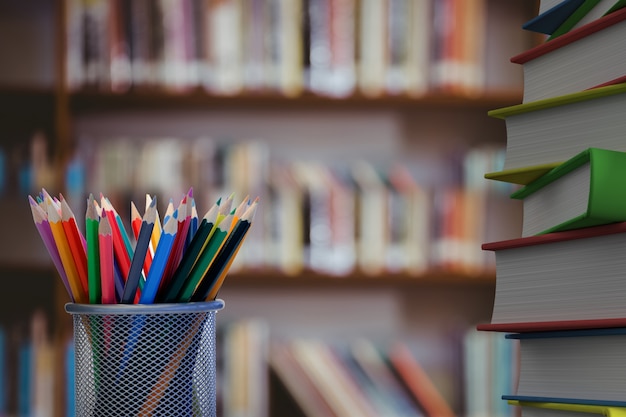 Close-up of colored pencils with books