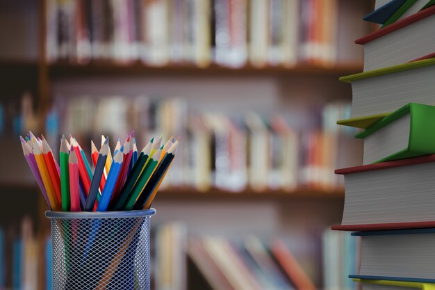 Close-up of colored pencils with books