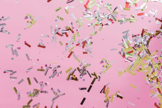 Close-up of colorful confetti on pink backdrop