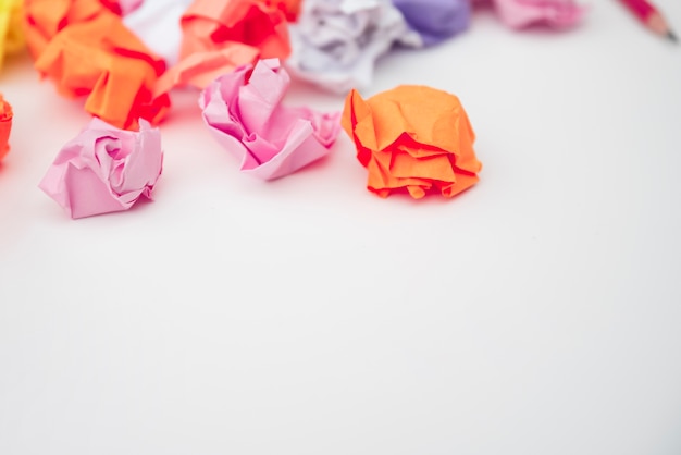 Close-up of colorful crumpled paper on white desk