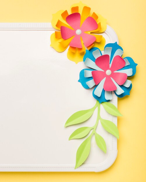 Close-up of colorful paper flowers on whiteboard