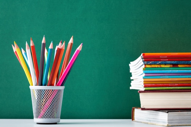 Close-up of colorful pencils with textbooks