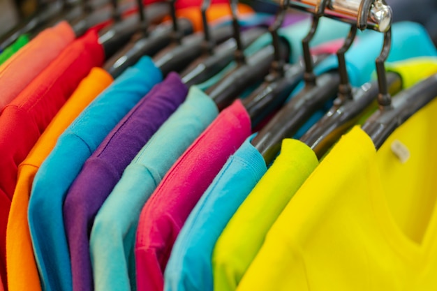 Premium Photo | Close up of t-shirts, clothes on hangers on white ...