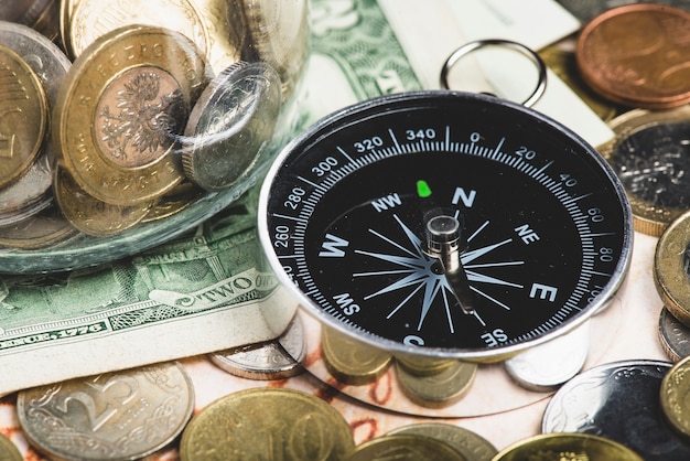 Close-up of compass with money to travel