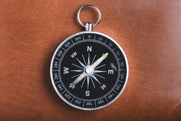 Close-up of compass on wooden background