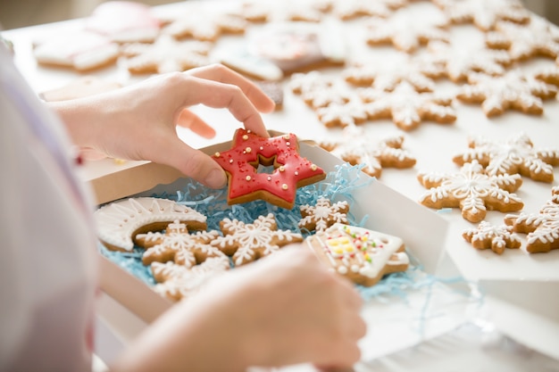 Close up of confectioner hand packing gingerbread cookies into b