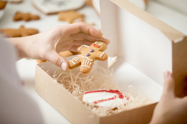 Close up of confectioner hand packing gingerman into a box