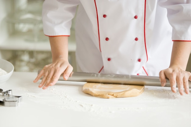 Close up of confectioner hands rolling gingerbread dough