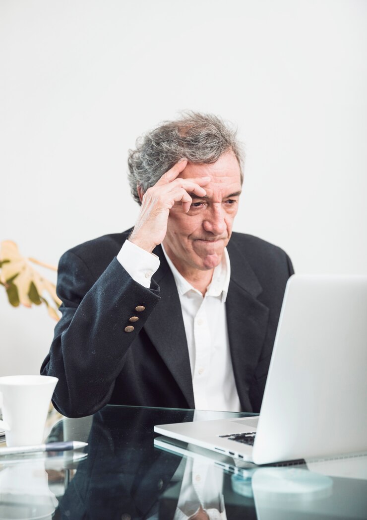 Free Photo close-up of contemplated senior man looking at laptop