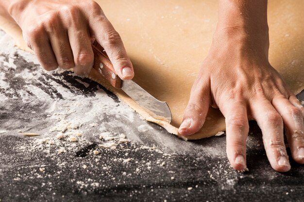 Close-up cook cutting dough