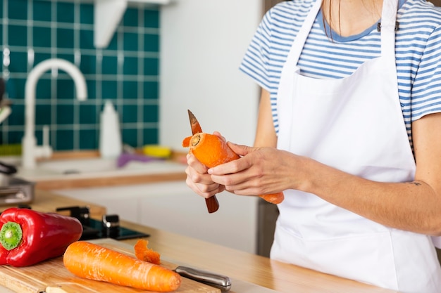 Free photo close up cook peeling carrot