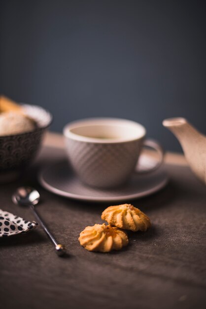 Close-up of cookies on table with tea cup in background