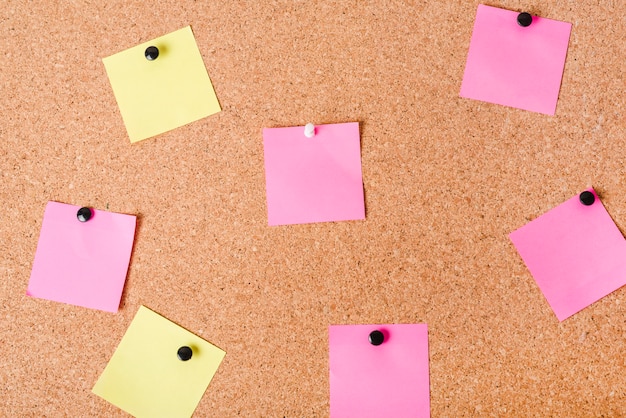 Close-up of corkboard with various note papers