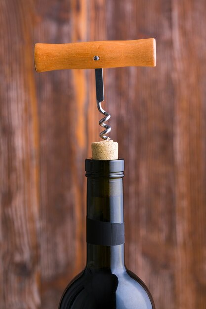 Close-up corkscrew and head of wine bottle with blurred background