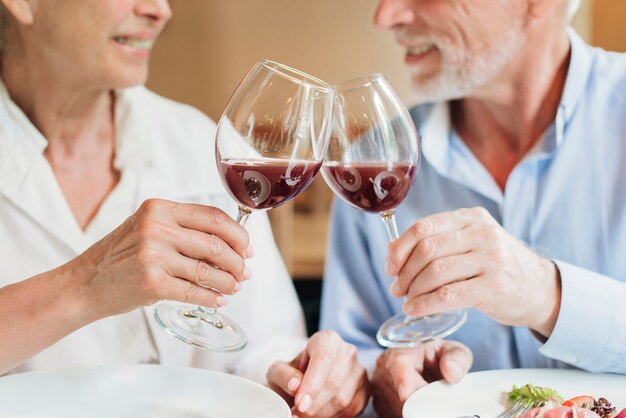 Close-up couple clinking glasses in a toast