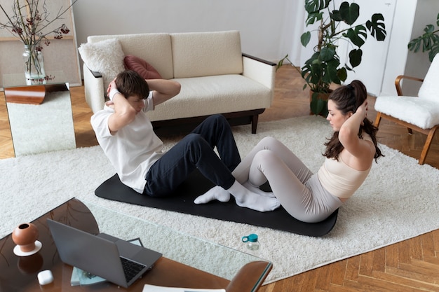 Close up on couple exercising after online instructor