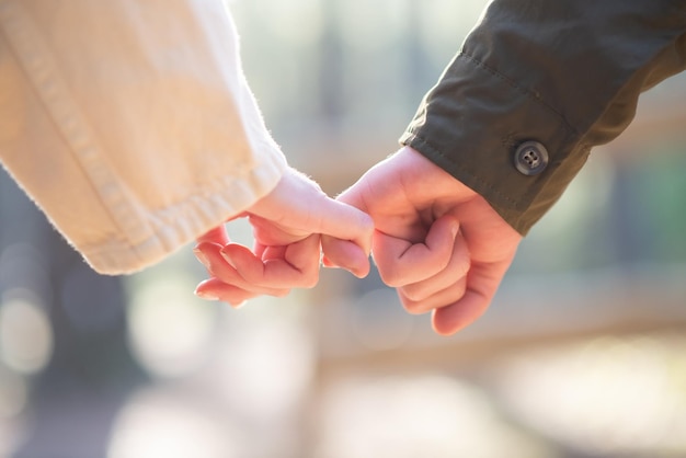 Free photo close-up of couple holding hands. caucasian couple holding each others little fingers. love, affection, relationship concept