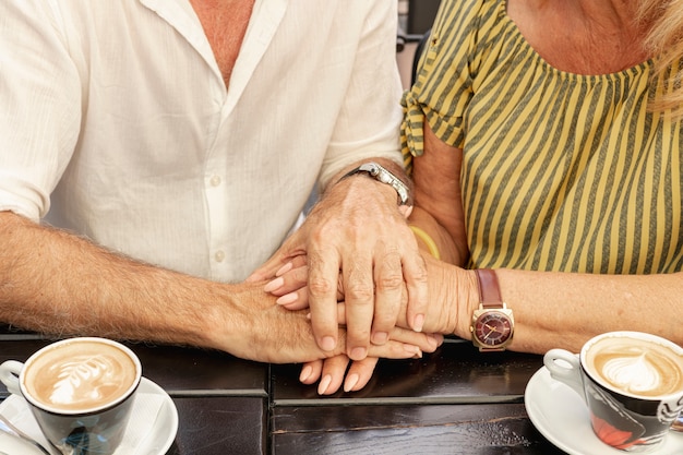 Close-up couple holding hands together