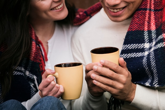 Close-up couple holding hot drinks