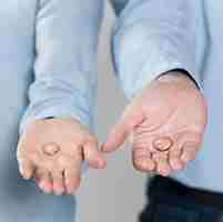 Free photo close-up couple holding wedding rings