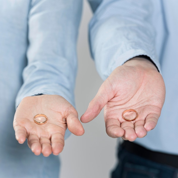 Close-up couple holding wedding rings