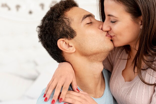 Close-up couple kissing in the bedroom