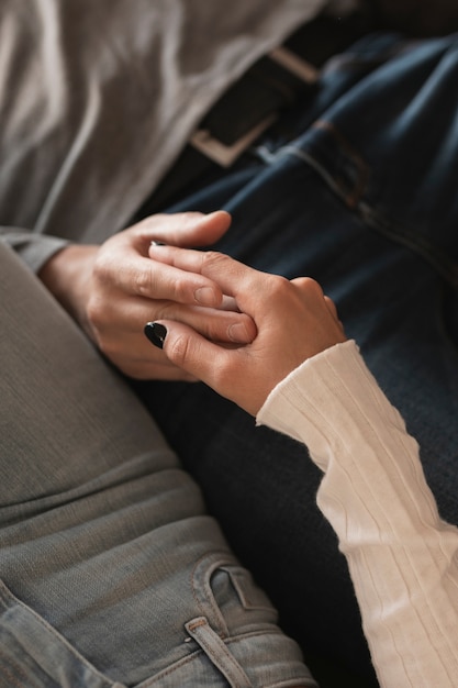 Close-up couple layed holding hands