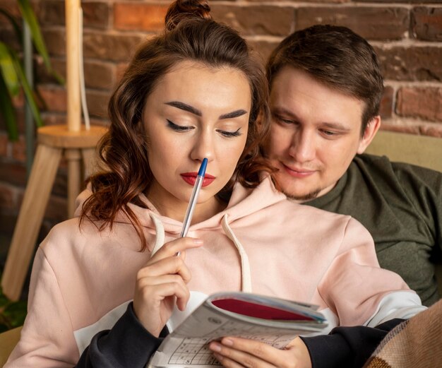 Close up couple making crossword puzzle