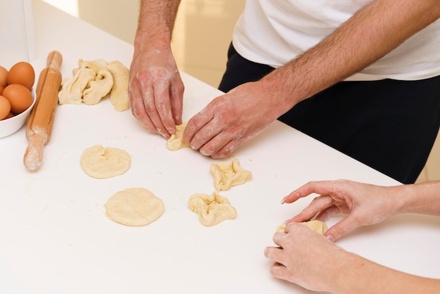 Close-up couple making shapes from dough