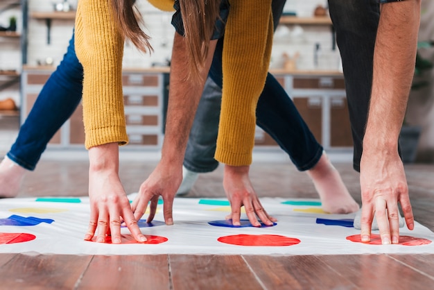 Close-up of couple playing at twister in house