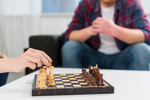 自宅で木製のチェス盤を遊ぶカップルのクローズアップ