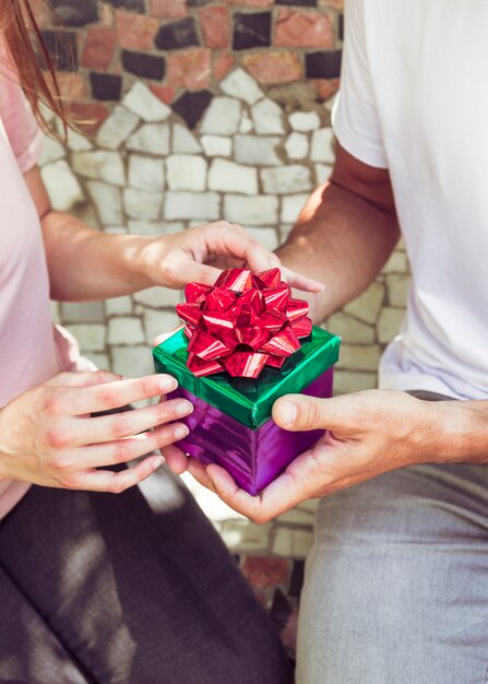 Close-up of a couple's hand holding gift box