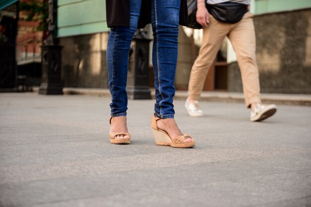通りを歩いてケッズでカップルの足のクローズアップ。