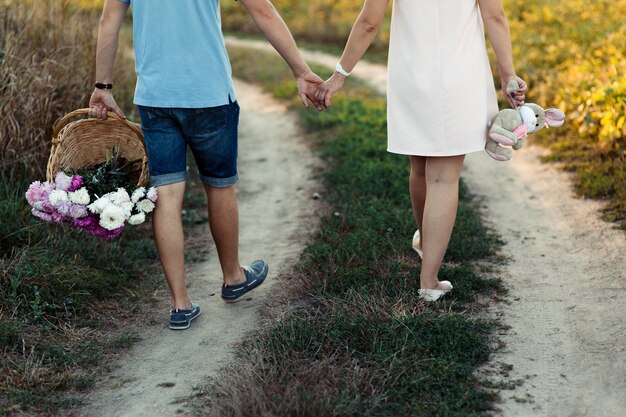 Close-up of couple's legs while they walk along green path 