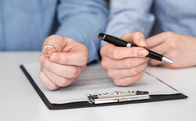 Close-up couple signing divorce contract