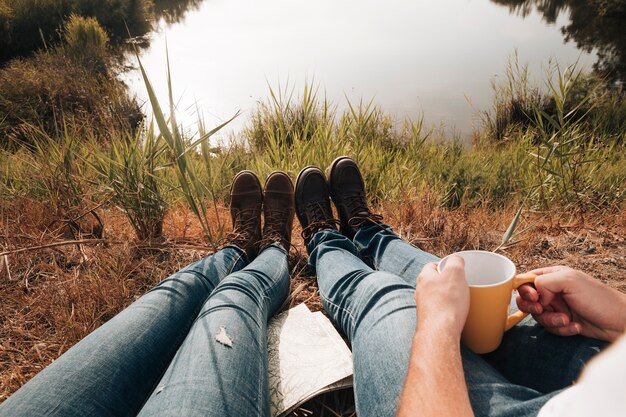 Close-up couple sitting next to lake