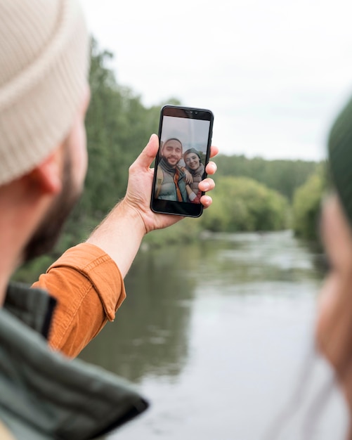 Close-up couple taking selfie near water